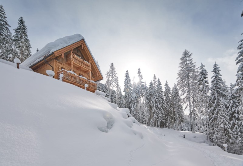 Eines unserer Chalets mit der Wintersonne im Hintergrund