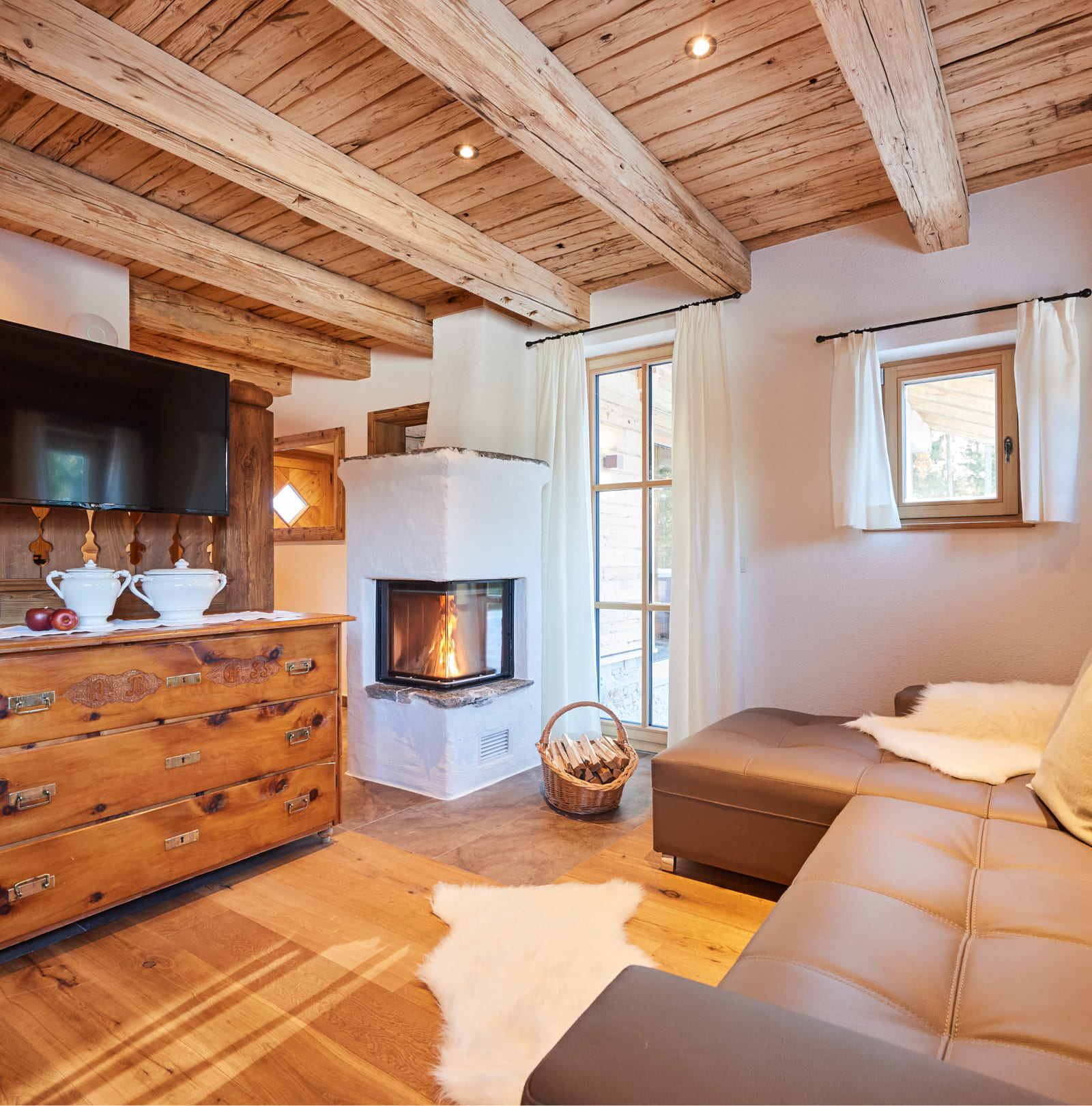 Wohnbereich mit Sofa, TV und Kamin im Chalet im Salzburger Land